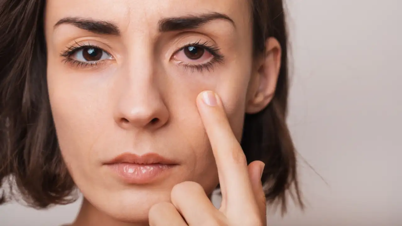 A woman with her finger on the side of her face.