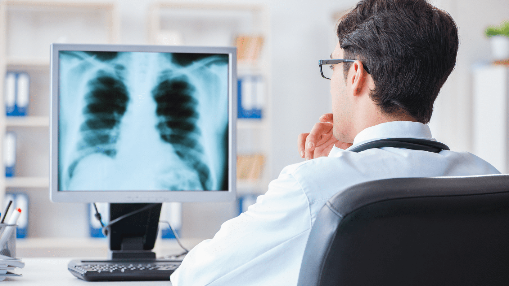 A doctor looking at an x-ray on his computer.