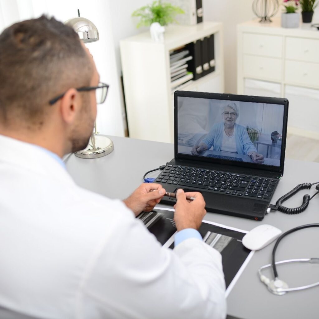 A doctor is sitting at the table and talking to someone.