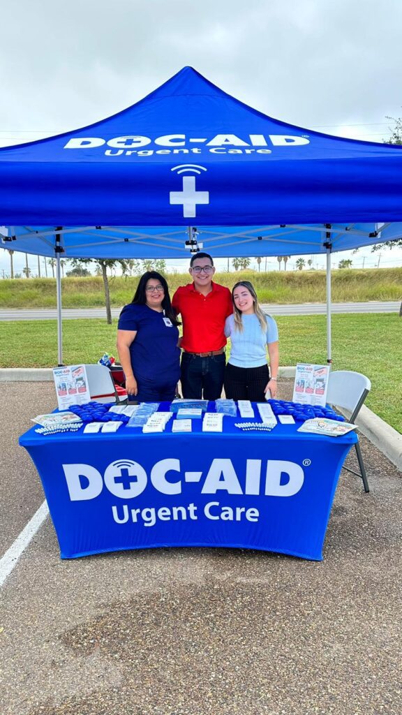 The people standing under a doc aid urgent care stand