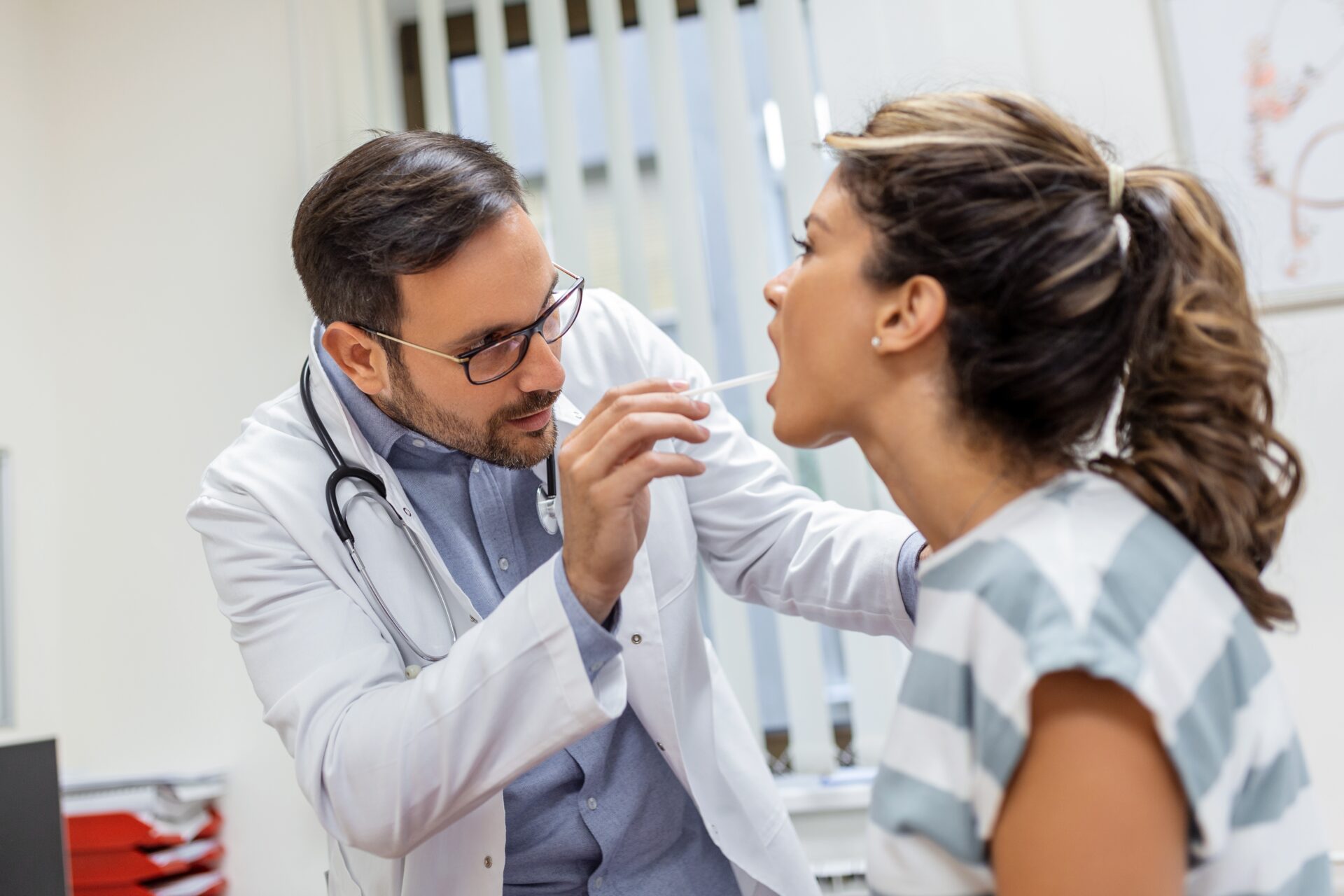 Doctor performing oral exam on patient.