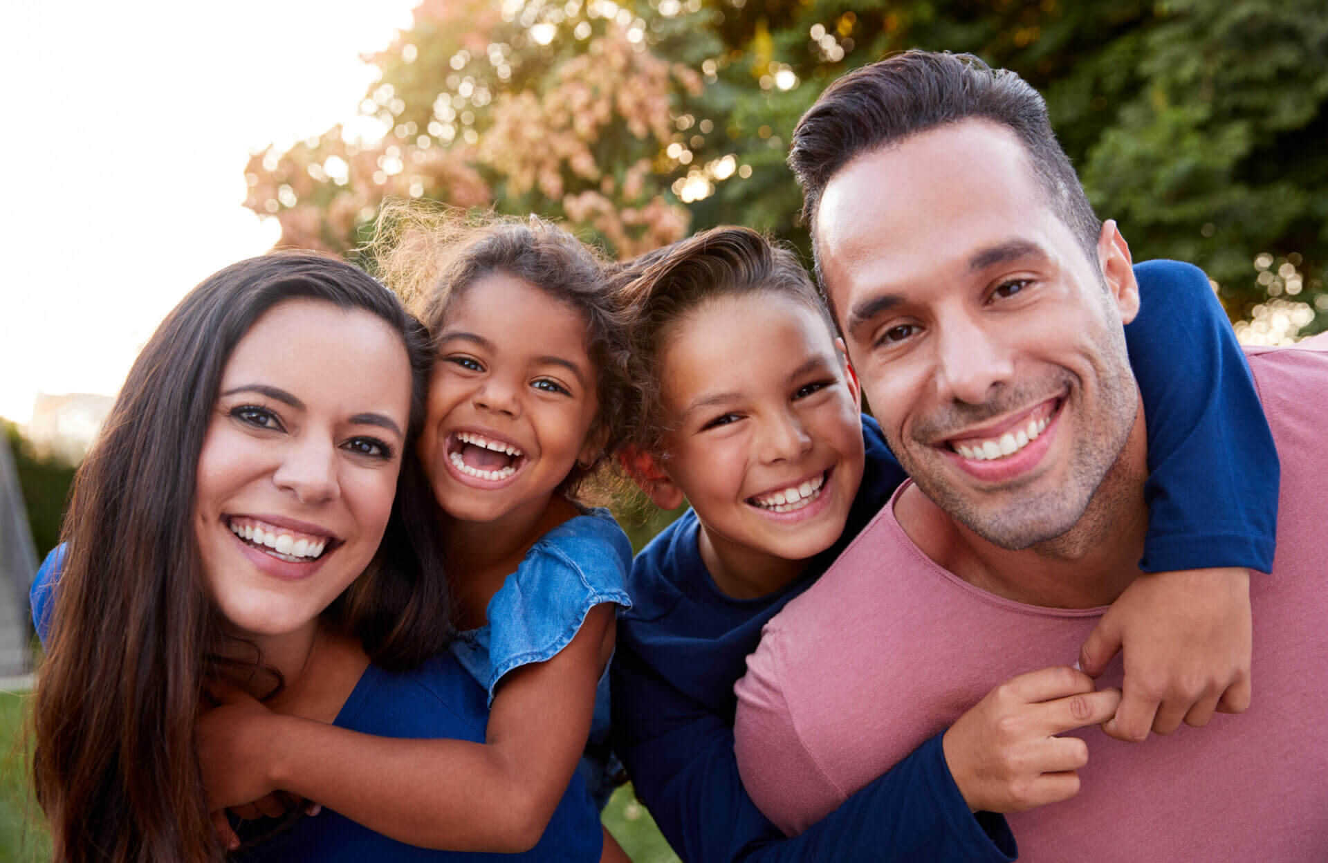 Portrait,Of,Smiling,Hispanic,Family,With,Parents,Giving,Children,Piggyback