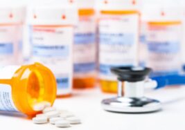 Prescription bottles and pills with stethoscope.