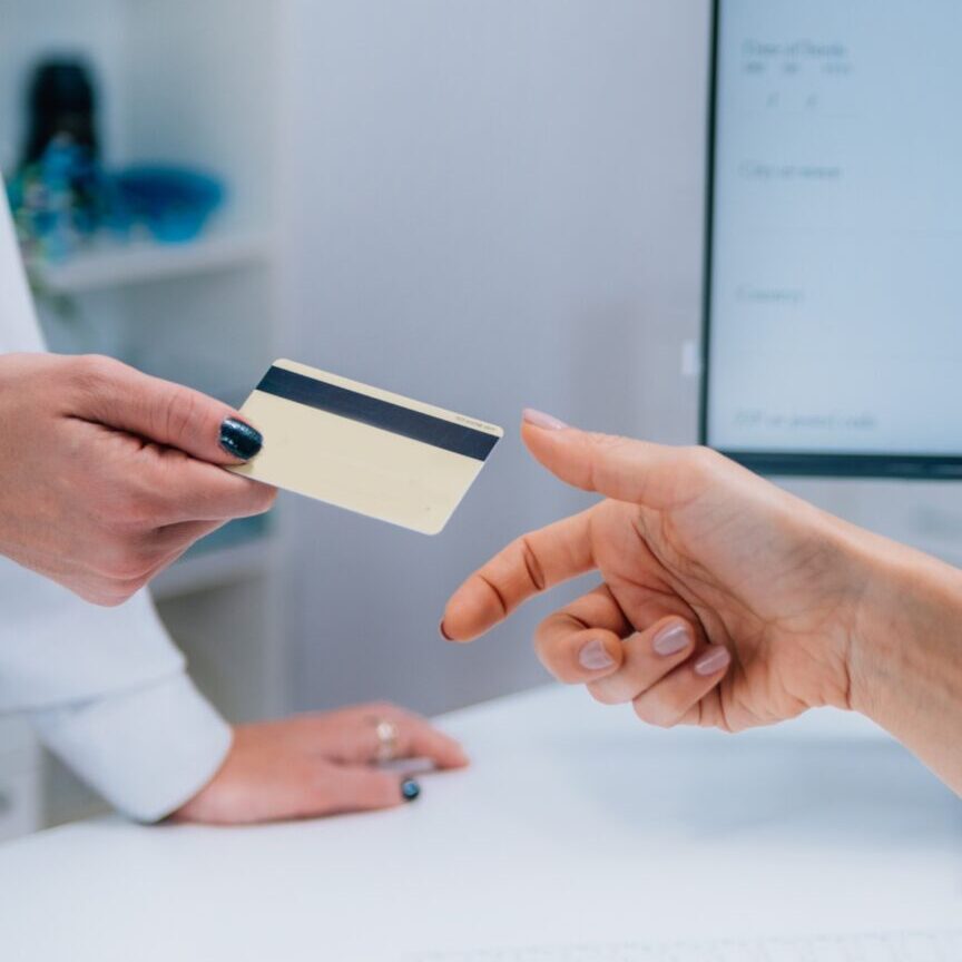 A person is handing over their credit card for payment to the doctor in laredo urgent care tx A person is handing over their credit card for payment to the doctor in laredo urgent care tx