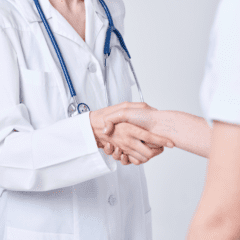 A doctor shaking hands with another person.