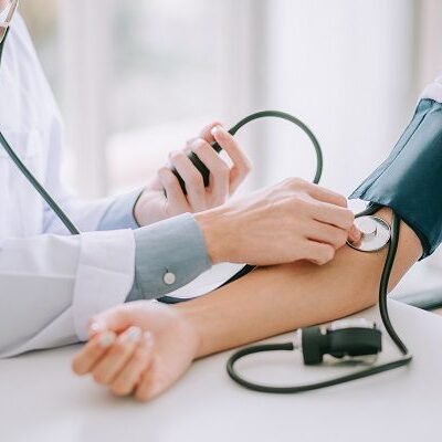 Doctor taking patient's blood pressure.