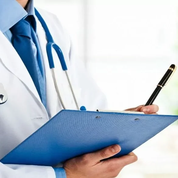 Doctor writing patient notes on clipboard.