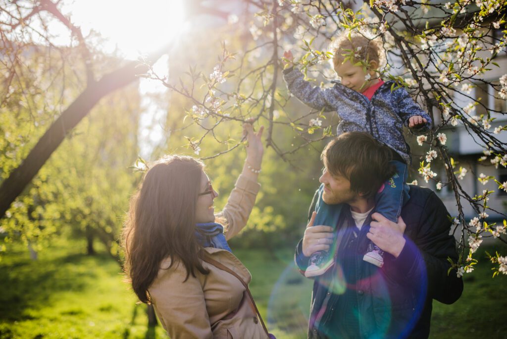 Family enjoying time under blooming tree.